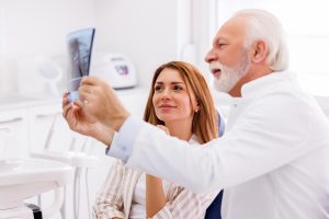 doctor-and-patient-looking-at-jaw-x-ray-at-dentist