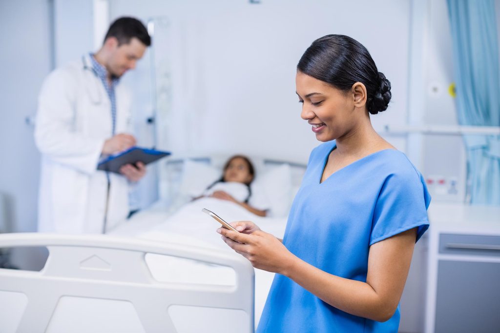 smiling-nurse-using-mobile-phone